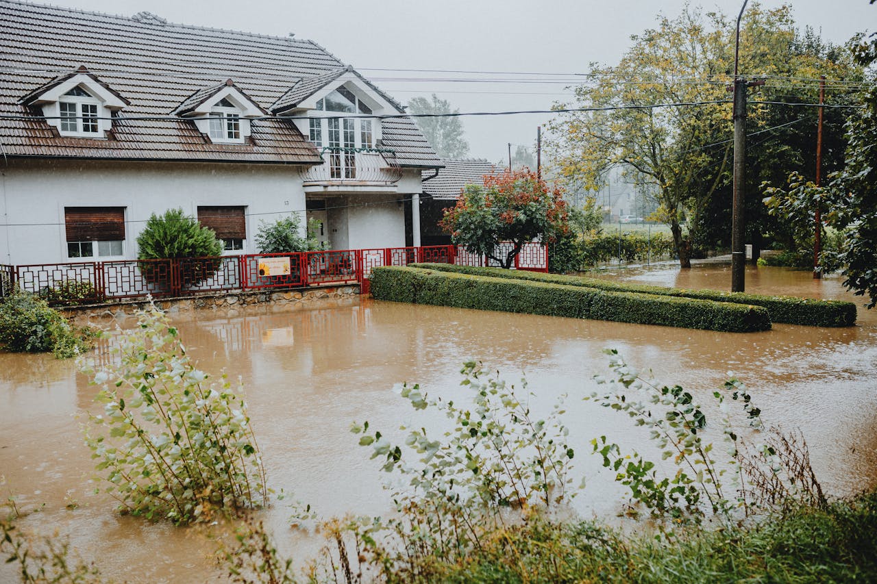 Crafting Captivating Headlines: Your awesome post title goes here A suburban house surrounded by floodwaters after heavy rain, showing impact of natural disaster.